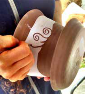 milly doing sgraffito on a pot